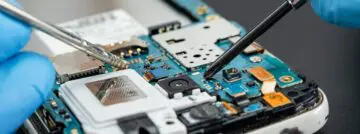 Technician,Repairing,Inside,Of,Mobile,Phone,By,Soldering,Iron.,Integrated