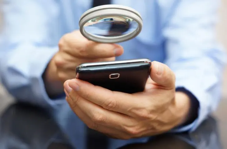 Businessman,Using,Mobile,Smart,Phone,With,Magnifying,Glass,.,Phone