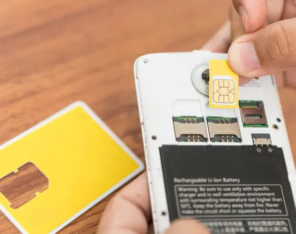 Hand,Insert,New,Sim,Card,With,Smart,Phone.