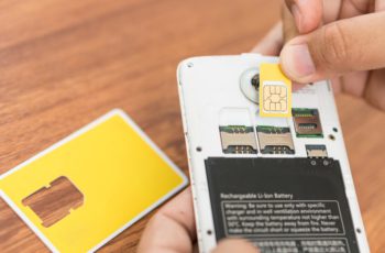 Hand,Insert,New,Sim,Card,With,Smart,Phone.